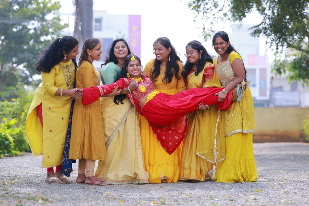 Bridesmaids joyfully carrying the bride during celebrations