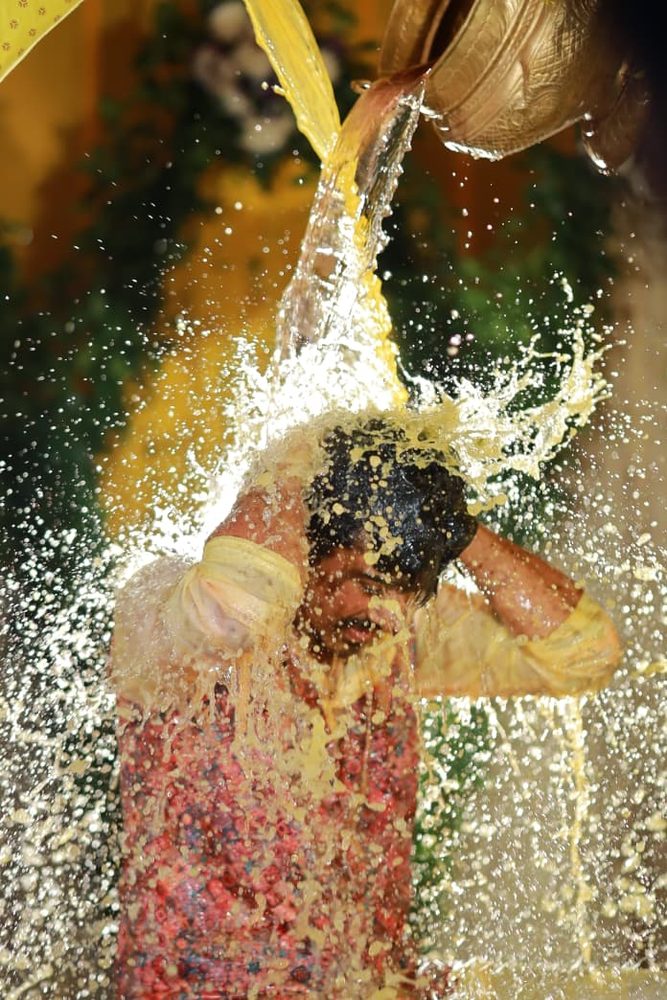 Haldi ceremony moment with turmeric water splash